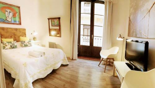 a bedroom with a bed and a flat screen tv at Donde Antonio in Granada