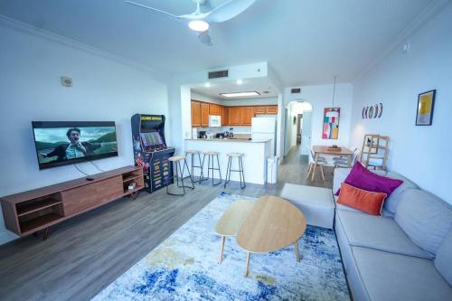 a living room with a couch and a tv and a kitchen at Aparment 2nd floor 5 minutes from Disney in Orlando