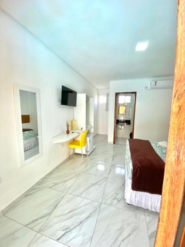 a bedroom with a bed and a desk in a room at Pousada O Sol De Maragogi in Maragogi