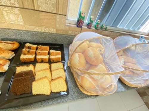 a counter with a bunch of bread and other foods at Pousada O Sol De Maragogi in Maragogi