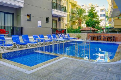 a swimming pool with blue chairs and a table at Miss Cleopatra Hotel in Alanya