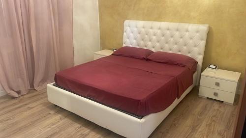 um quarto com uma grande cama branca com lençóis vermelhos em Maison Valentina em Marendole