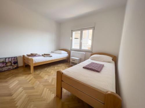 a bedroom with two beds and a window at Villa Ellie in Ljubuški