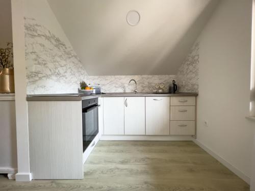 a kitchen with white cabinets and a sink at Villa Ellie in Ljubuški