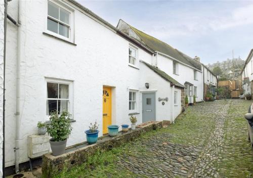 a row of white houses with potted plants on the street at Sea Shanty Cottage in Newlyn