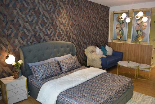 a bedroom with a bed and a couch and a chair at Luxxe interior design condo @ Novotel Suites Manila - Acqua in Manila
