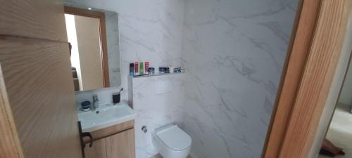 biała łazienka z toaletą i umywalką w obiekcie room in Residence Lilya fermée et sécurisée w mieście Casablanca