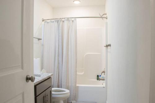 a white bathroom with a toilet and a shower at Urban Oasis in University City in Philadelphia