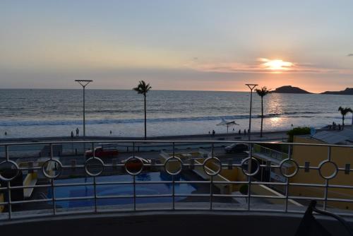 a view of the beach and the ocean at sunset at Departamento en Torre Miramar, Malecón de Mazatlán in Mazatlán
