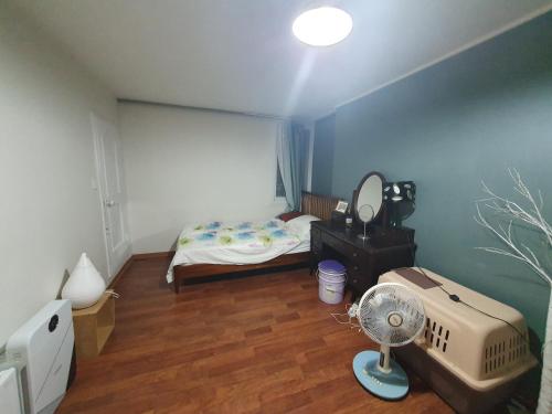 首爾的住宿－Heukseok Town House，一间卧室配有一张床和一个风扇