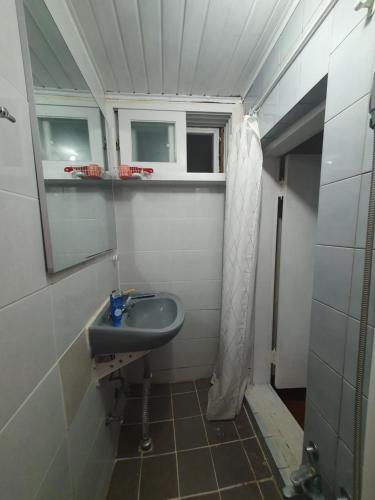 a small bathroom with a sink and a mirror at Heukseok Town House in Seoul