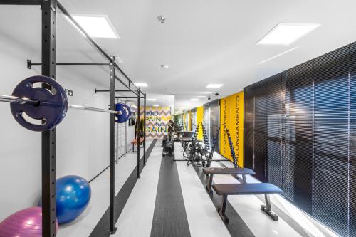 a room with a gym with a bench and dumbbells at All You Need in Curitiba