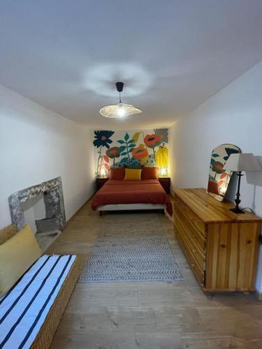 a bedroom with a bed and a couch in a room at Joli logement au calme in Vésonne