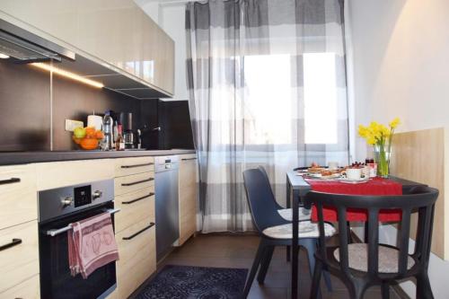 eine Küche mit einem Tisch, Stühlen und einem Herd in der Unterkunft Das Falk Apartmenthaus in Nürnberg