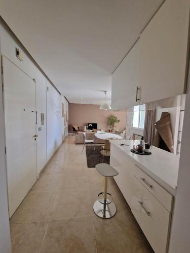a kitchen with white cabinets and a table in a room at CityCosy Super Moderne, Confortable, Spacieux et Calme in La Marsa