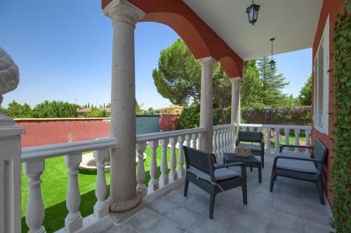 a patio with chairs and a table on a balcony at Lillo Rural in Toledo