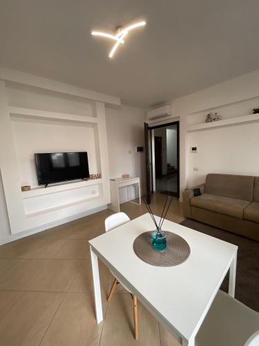 un soggiorno con un tavolo bianco e un divano di casa manuel a Gallarate