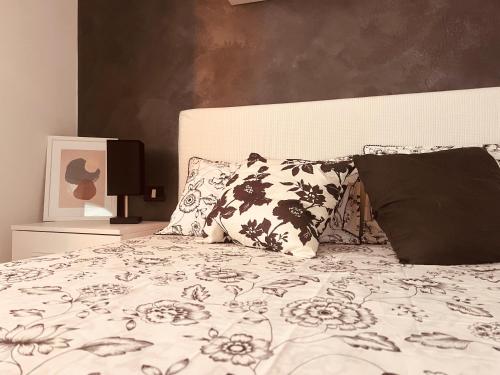 - un lit avec des draps et des oreillers en noir et blanc dans l'établissement Canovine 13, à Bergame