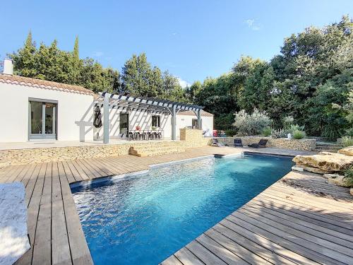- une piscine dans un jardin avec une terrasse en bois dans l'établissement Villa Palmera, à Saint-Cyr-sur-Mer