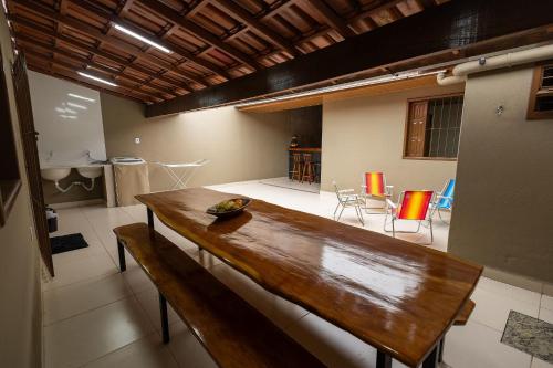 Habitación grande con mesa de madera y sillas. en Casa Temporada Guriri Pé na areia!, en São Mateus
