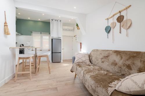 un salon avec un canapé et une cuisine dans l'établissement Charmant studio plein centre des couverts, calme et climatisé, à Mirepoix