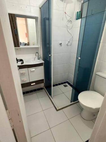 een badkamer met een douche, een toilet en een wastafel bij Apto no centro de Bertioga in Bertioga