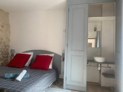 - une chambre avec un lit doté d'oreillers rouges et d'un lavabo dans l'établissement Palais PépinleBref Chateaux de la Loire Tours - 3 étoiles, à Vernou-sur-Brenne