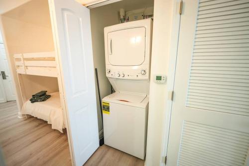 eine kleine Küche mit Waschmaschine und Trockner in einem Zimmer in der Unterkunft Orlando Apt 9th Floor 5 min from Disney in Orlando