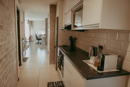 ウィントフークにあるNAMIB Suite - Luxury Apartment near Grove Mall & Hospital Airbnbのキッチン(カウンタートップ付)