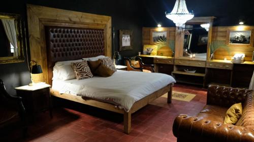 een slaapkamer met een bed, een bank en een stoel bij Estancia Don Joaquín Argentina in Esquina