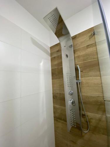 a shower in a bathroom with a wooden wall at Dpto con hermosa vista al hipódromo de Monterrico in Lima