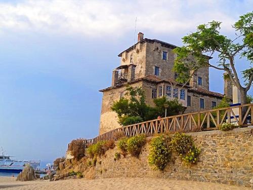 an old building sitting on top of a stone wall at Yulia Luxury Apartments in Ouranoupoli