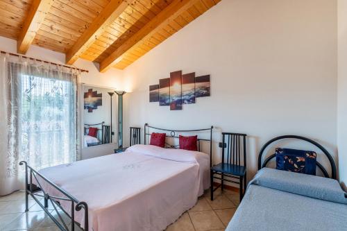 una camera con due letti e una finestra di residence la corte near Gardaland a Castelnuovo del Garda