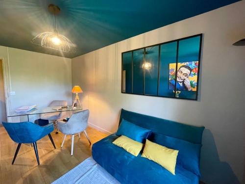 sala de estar con sofá azul y escritorio en Chambre calme Ouest Lyonnais, en Lentilly