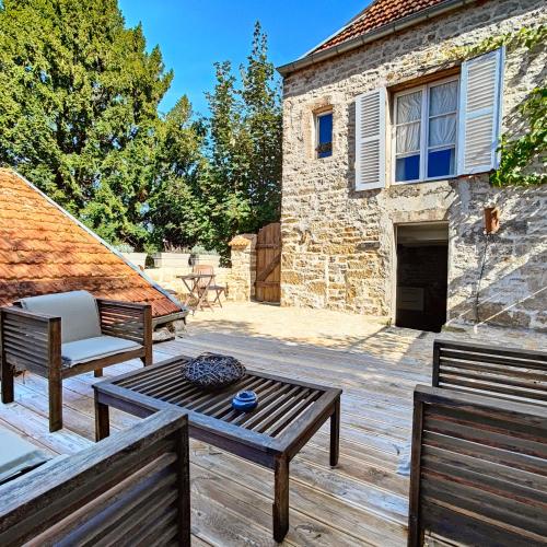 a patio with two benches and a table and a building at Tourellerenard in Bussières-lès-Belmont
