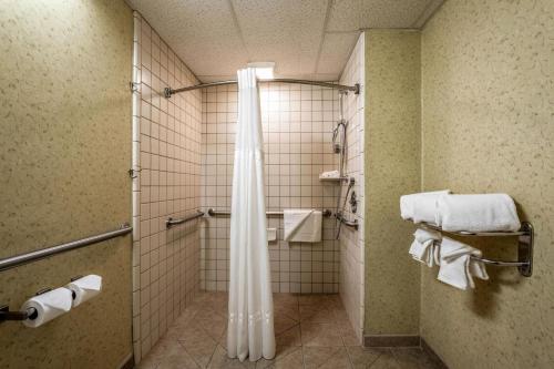 a bathroom with a shower curtain and towels at Quality Suites Downtown San Luis Obispo in San Luis Obispo