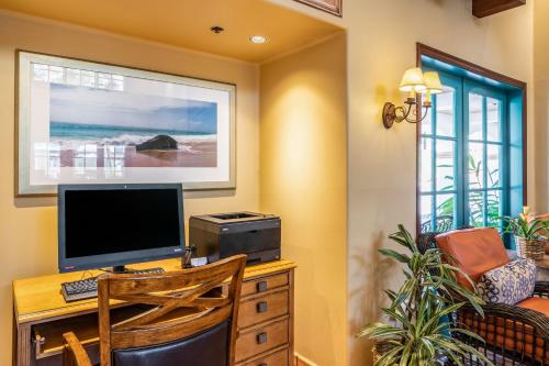 a computer desk with a computer monitor and a printer at Quality Suites Downtown San Luis Obispo in San Luis Obispo