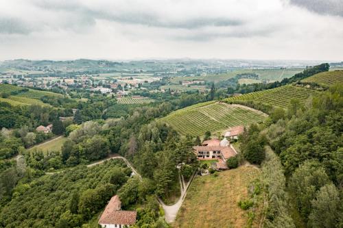 an aerial view of a vineyard with a house on a hill at Cadgal - Tenuta La Cova in Calamandrana