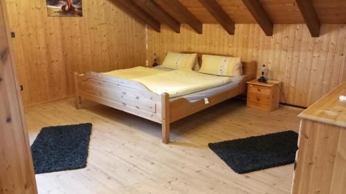 ein Schlafzimmer mit einem Bett in einer Holzhütte in der Unterkunft Ferienwohnung in Mörlenbach
