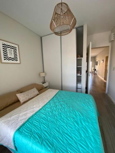 Un dormitorio con una cama grande y una lámpara de araña. en Start San Martín 2 en Buenos Aires