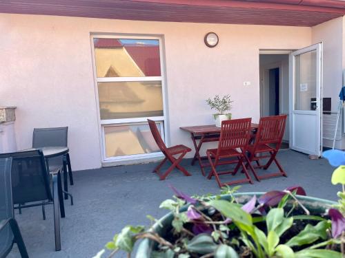 a patio with chairs and a table and a clock at Boutique Apartments Oradea in Oradea