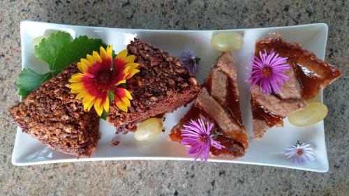 LA CASA DEI MASUE' في ألبا: طبق من الطعام مع كعكة وزهور عليه