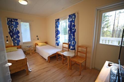 a room with two beds and a table and chairs at Overkalix Holiday Home with Sauna in Jock