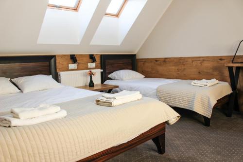 um quarto com 2 camas e toalhas brancas em Hotel Regina em Radom