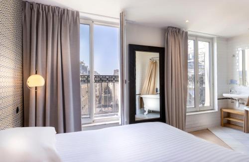 パリにあるHôtel Emile Le Maraisのベッドルーム1室(ベッド1台付)が備わります。バスルームの景色を望めます。
