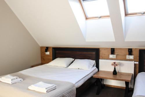 a bedroom with two beds and a table at Hotel Regina in Radom