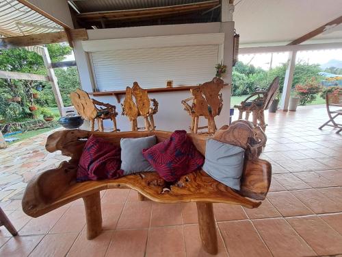 a wooden couch with pillows on a patio at La Poz Kreyol Appartement à la campagne in Le Lamentin