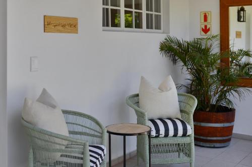 two chairs and a table in a room with plants at Fransvliet Guest House in Franschhoek