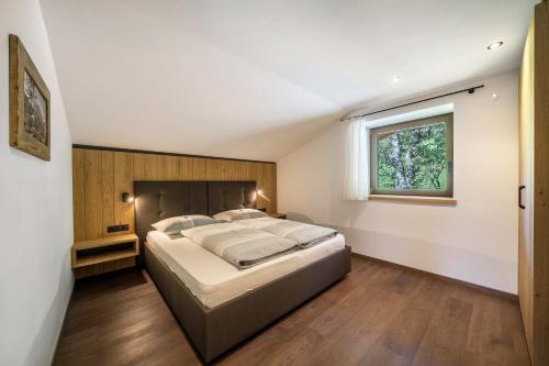 Un dormitorio con una cama grande y una ventana en Sunnseitn Lodge Apt Mountainsuite, en Stulles