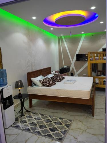 um quarto com uma cama com um tecto azul e verde em Residence NOURAH em Rufisque